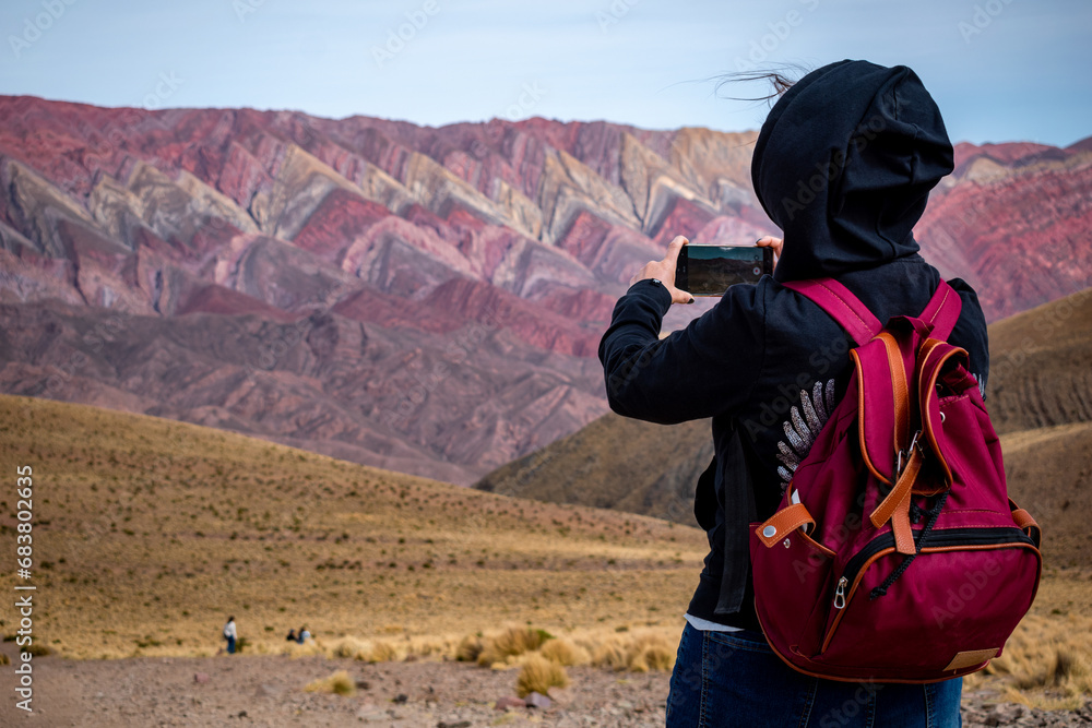 Mujer turista tomando una foto en su excursión por el Hornocal, en Jujuy, Argentina Mujer turista tomando una foto en su excursión por el Hornocal, en Jujuy, Argentina