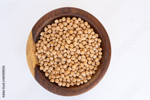 chickpeas on a wooden plate isolated on a white background