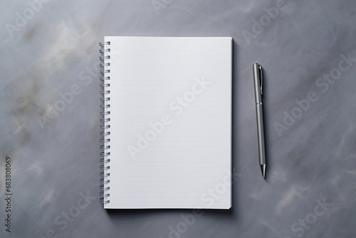 notepad and a pen on an untitled grey surface.mock up photo