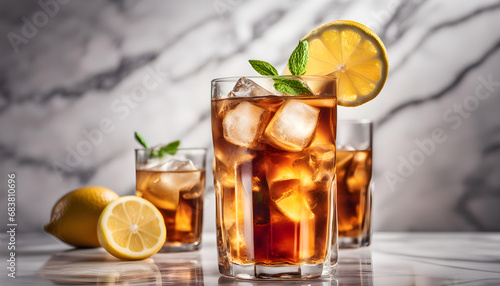 fresh and cool ice tea in glass, with shiny light reflection in white marble background