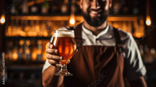Freshly tapped beer. Bartender holding a freshly tapped glass of beer in his hand with copy space
