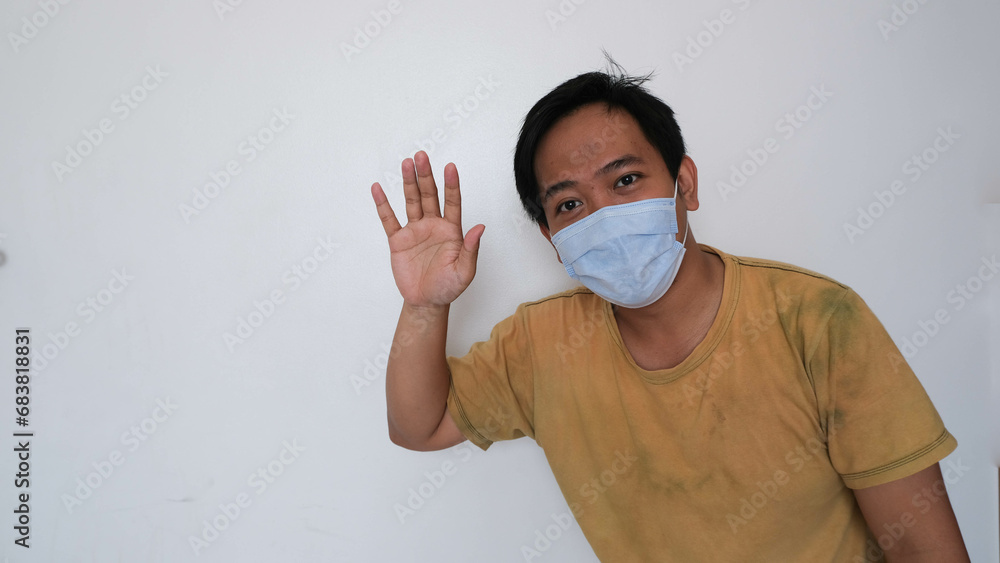 Man in a face mask gesturing stop, promoting health safety Man in a face mask gesturing stop, promoting health safety