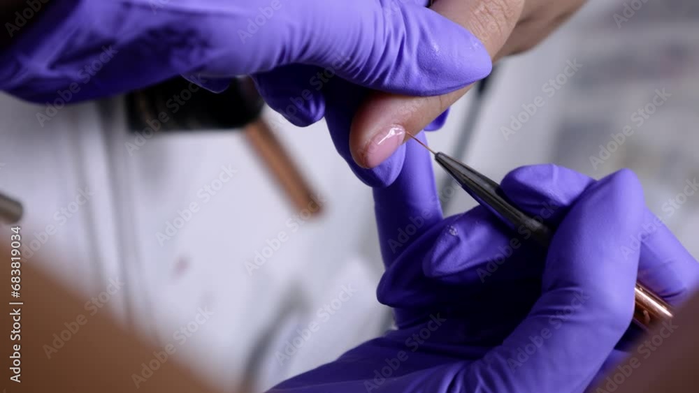 A vertical close up of manicurist correcting pink polish to a woman's nails under the supervision of her mentor A vertical close up of manicurist correcting pink polish to a woman's nails under the supervision of her mentor