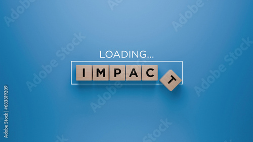 Wooden blocks spelling 'IMPACT' with a loading progress bar on a blue background, making difference concept