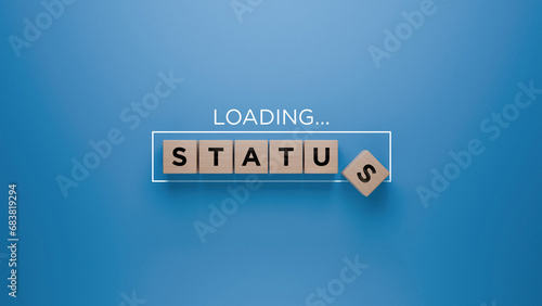 Wooden blocks spelling 'STATUS' with a loading progress bar on a blue background, social standing and ranking concept