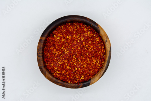 Dry chili peppers on a wooden plate isolated on a white background
