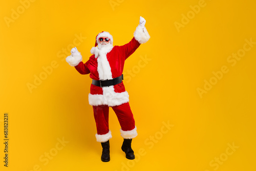 Full body photo of satisfied aged santa raise fists triumph empty space christmas noel ad isolated on yellow color background