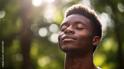 Headshot of a young African man breathing fresh air in a hazy park under the morning sun