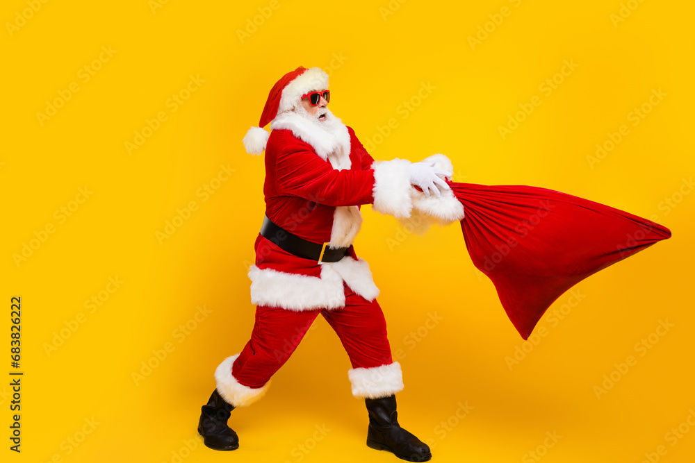 Full body portrait of impressed santa claus arms throw catch christmas gifts bag empty space isolated on yellow color background Full body portrait of impressed santa claus arms throw catch christmas gifts bag empty space isolated on yellow color background