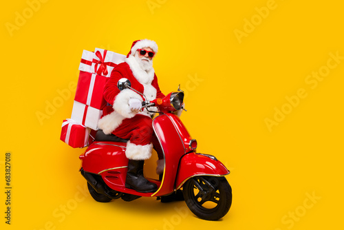 Full length photo of riding moped saint nicholas courier express new year delivery from north pole isolated on yellow color background
