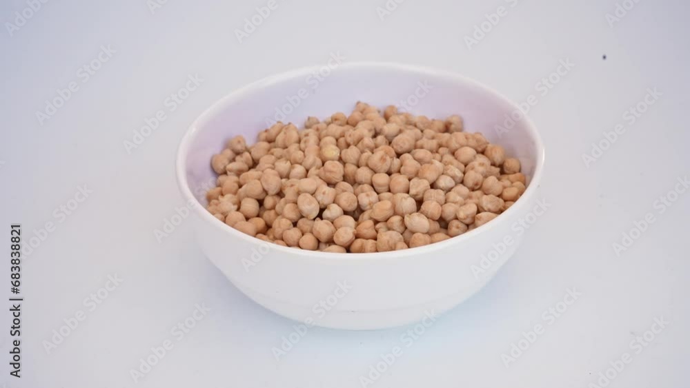 chickpeas falling in a white plate on a white background
chickpeas falling in a white plate on a white background