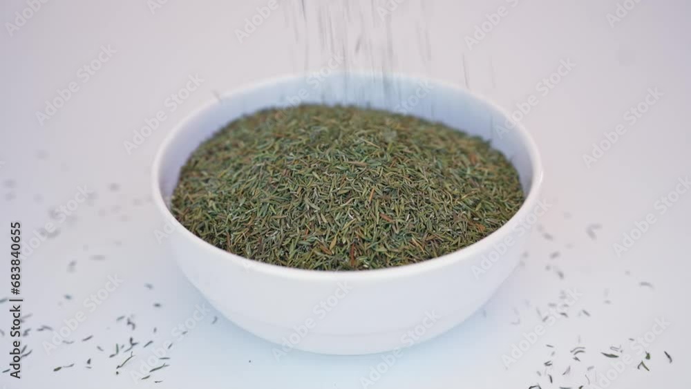 Crushed dried basil falling from hands on glass plate, white background Crushed dried basil falling from hands on glass plate, white background