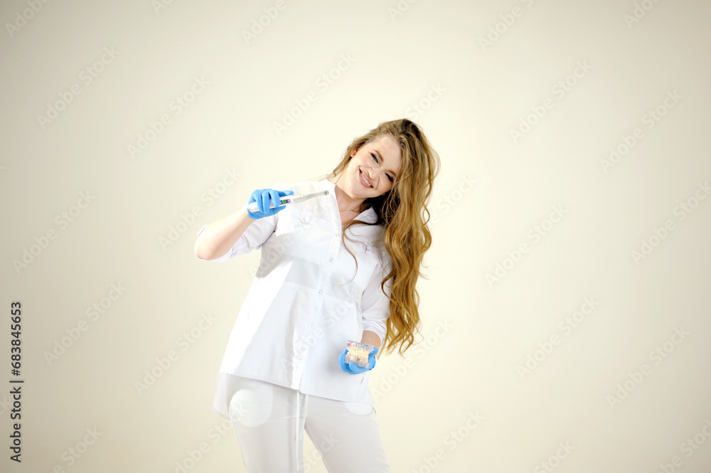 Photopolymer lamp Doctor Fairy with a glowing blue lamp in a white medical suit Dentist treatment of teeth prosthetics put fillings treat gums caries beautiful woman on white background. studio ad Photopolymer lamp Doctor Fairy with a glowing blue lamp in a white medical suit Dentist treatment of teeth prosthetics put fillings treat gums caries beautiful woman on white background. studio ad