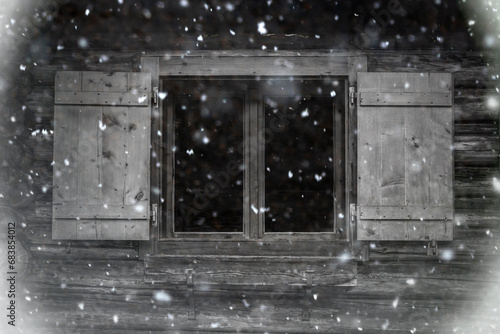 Schneetreiben vor einem rustikalen Holzfenster einer almhütte