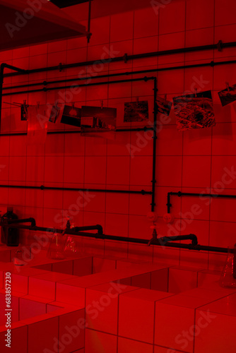 Vertical photo of a darkroom with chemicals for developing photographs under red light
