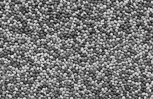 Seamless Coarse Sand Textured Surface: A Monochrome View. Seamless pattern of small stones in varying shades of gray creates a detailed and uniform texture, ideal for backgrounds and design elements