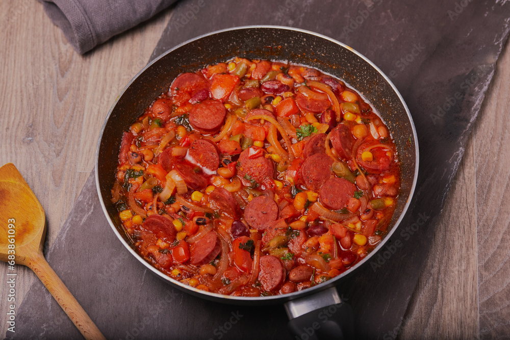 Chorizo stew resting in a pan shot from above.
