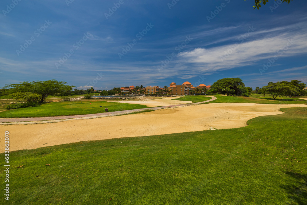 Beautiful view of golf course on island of Aruba, set against backdrop of tropical vegetation and hotel. Beautiful view of golf course on island of Aruba, set against backdrop of tropical vegetation and hotel.