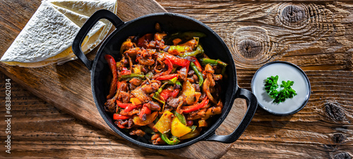 Fajita with peppers and onions served on a hot iron skillet