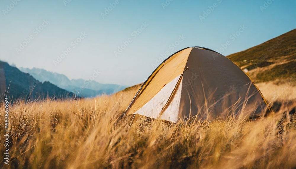 Camping in the wilderniss: Wonderful spot for heaving a calm night in the tent. Sunset scenery with golden light on the mountain in high grass. travel and adventure concept