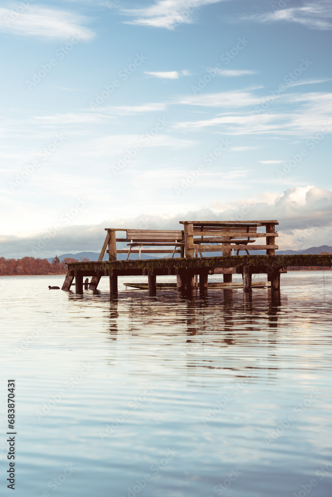wooden pier with a bench at a lake