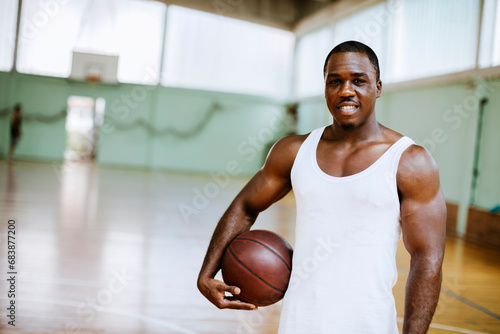 Portrait of a young male basketball player in an indoor basketball gym photo