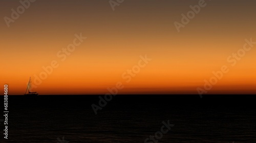 A lone sailboat on the horizon at sunset, its sails glowing orange against the dimming sky © Татьяна Креминская