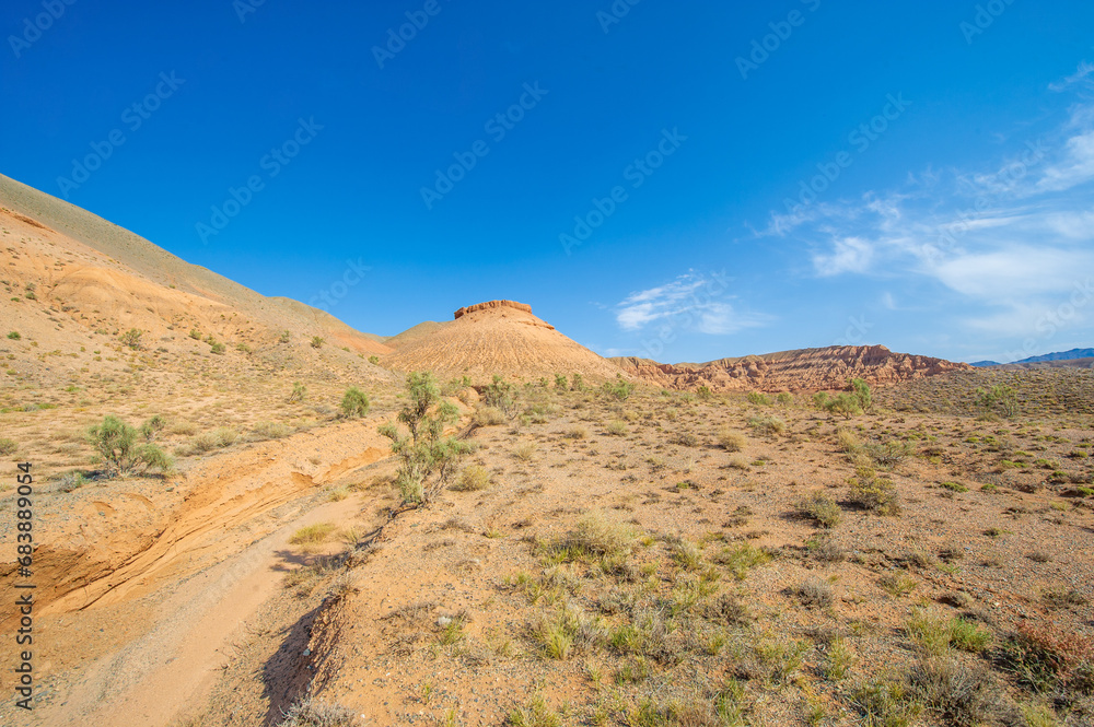 Enjoy the beauty of a desert sunset in the Red Boguta Mountains. Witness the golden glow of the sun illuminating the jagged peaks. Be enchanted by the breathtaking scenery of the Fire Wonders.