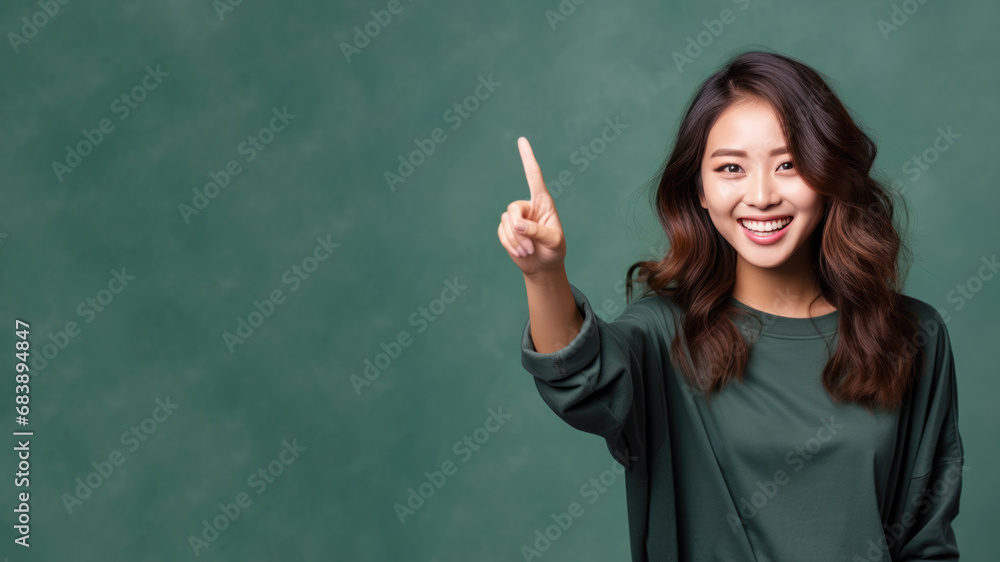 Happy asian woman pointing her finger at copy space for promotion Happy asian woman pointing her finger at copy space for promotion