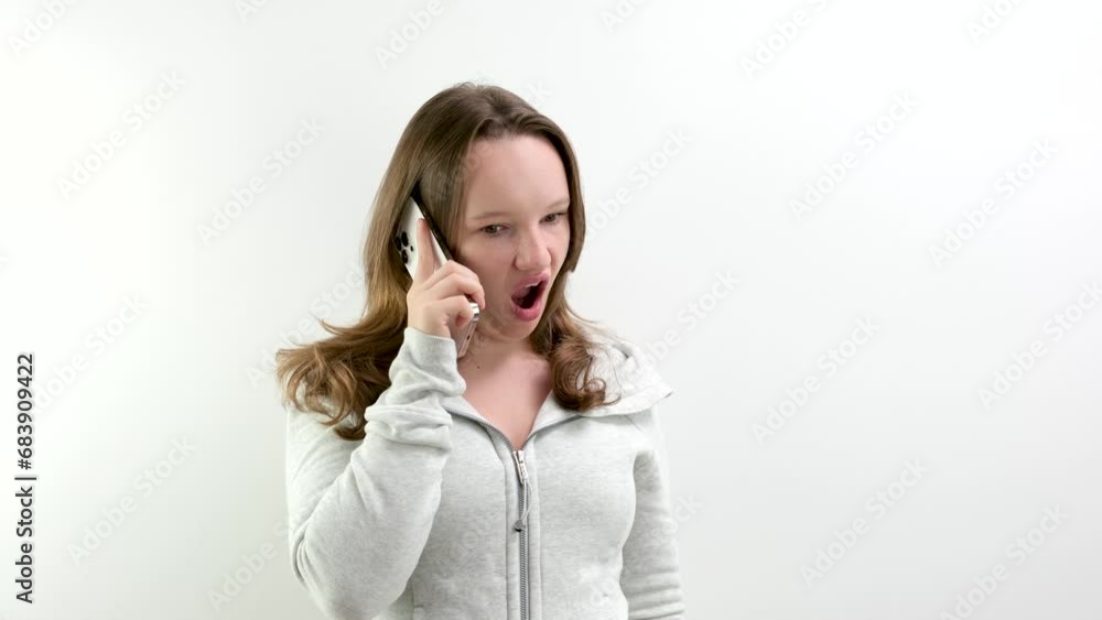 Frustrated annoyed sad woman with mobile phone standing intside. white background Frustrated annoyed sad woman with mobile phone standing intside. white background