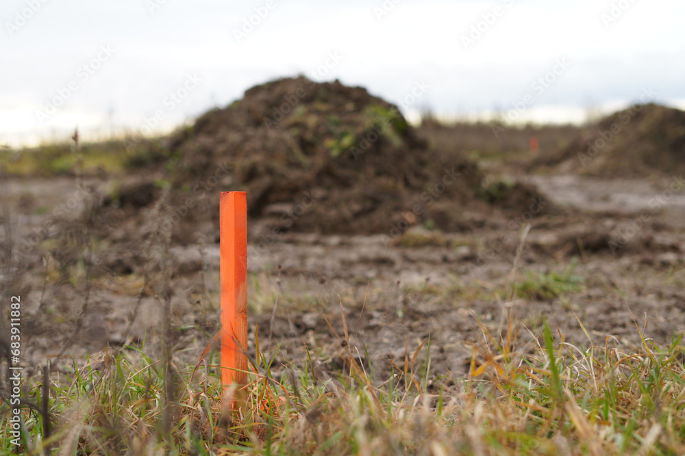 An orange stake in the ground that marks the boundary of the property