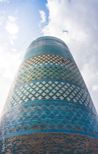 Facing of the Kalta Minar from glazed mosaic tiles in the ancient city of Khiva in Khorezm photo