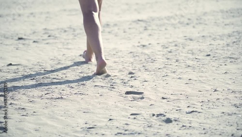 Gambe della donna che cammina sulla spiaggia photo