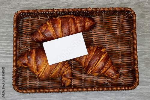 white card business above Fresh croissants in esparto halfah basket photo