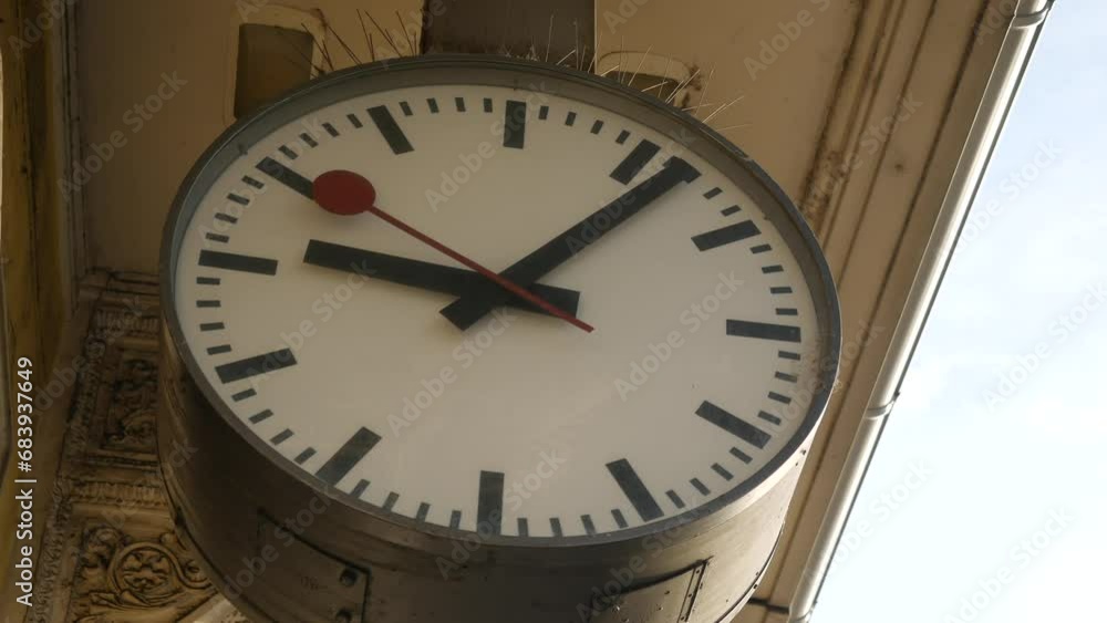 Large clock face with arrows at railroad station. Red second hand moves forward slowly. Old fashion analog clock. Antique stucco on the building. Ljubljana, Slovenia - November 24, 2023 Large clock face with arrows at railroad station. Red second hand moves forward slowly. Old fashion analog clock. Antique stucco on the building. Ljubljana, Slovenia - November 24, 2023