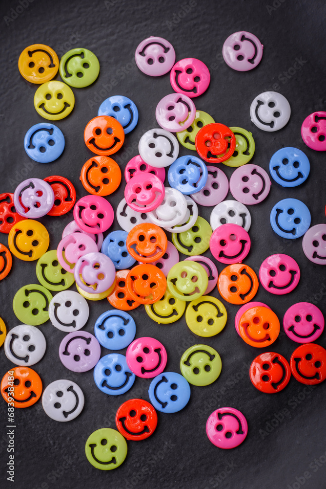 A concept consisting of the inscription of the word smile, with round emoticons on a dark concrete background A concept consisting of the inscription of the word smile, with round emoticons on a dark concrete background