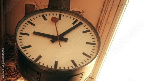 Time machine concept. Clock hands move in opposite direction. Return to past. Wayback machine. Large clock face at station. Antique stucco on old building. Ljubljana, Slovenia - November 24, 2023