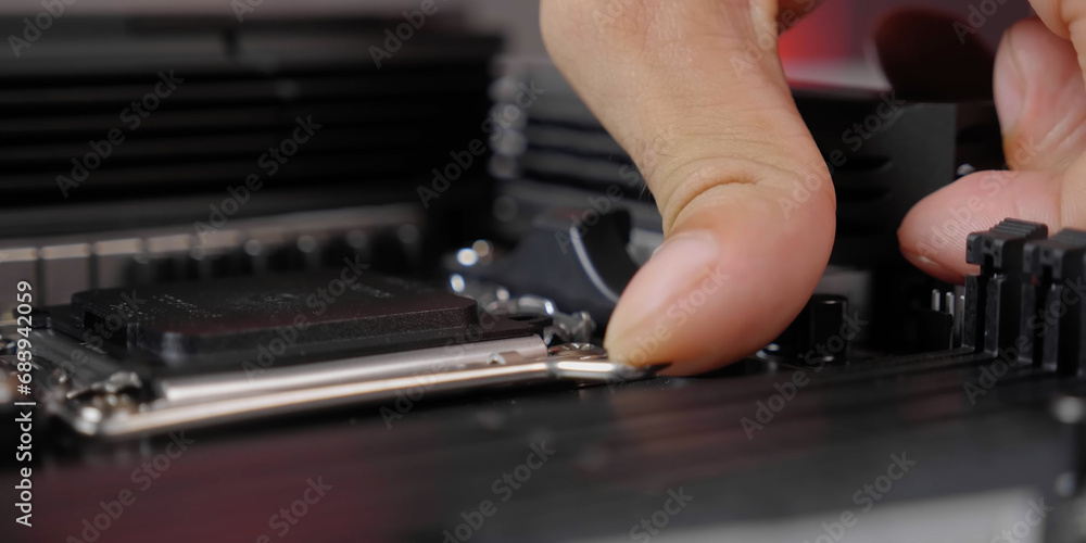 Technician examines microprocessor chip on PC motherboard. 
