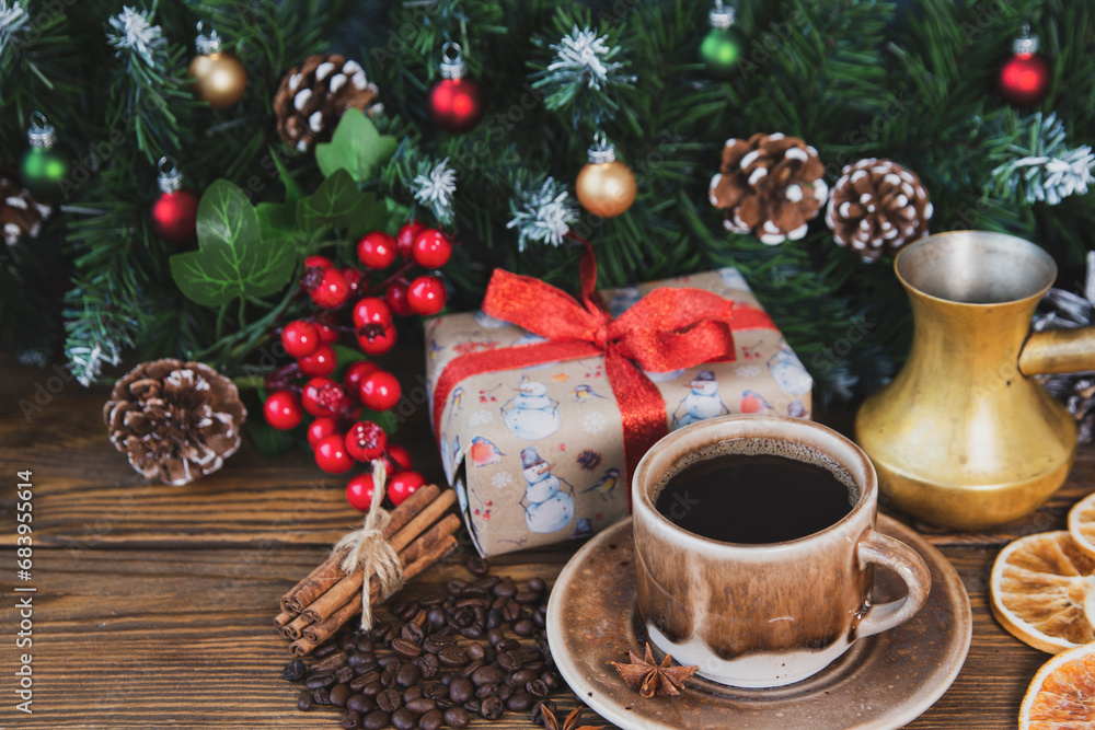 Christmas mood, holiday atmosphere. Red cup of coffee, fir branches with cones, Christmas gifts, star anise on a wooden table background. Christmas mood, holiday atmosphere. Red cup of coffee, fir branches with cones, Christmas gifts, star anise on a wooden table background.