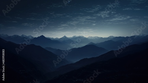  a view of a mountain range at night with the moon in the sky and a few clouds in the sky.