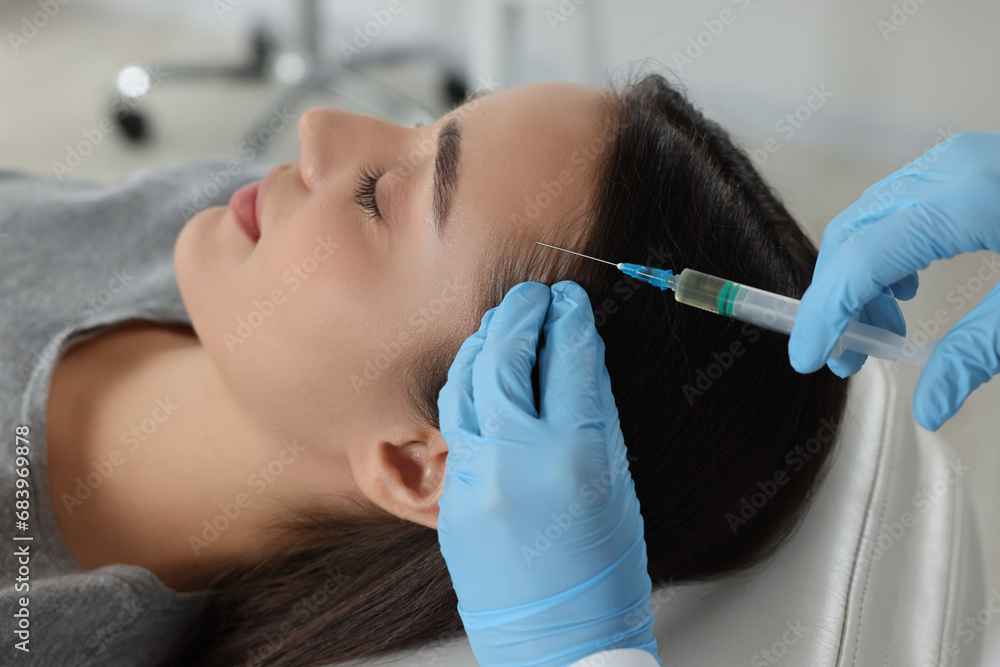 Fototapeta premium Trichologist giving injection to patient in clinic, closeup