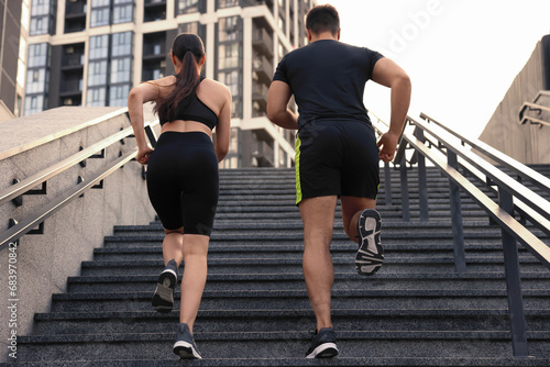Healthy lifestyle. Couple running up steps outdoors  low angle view