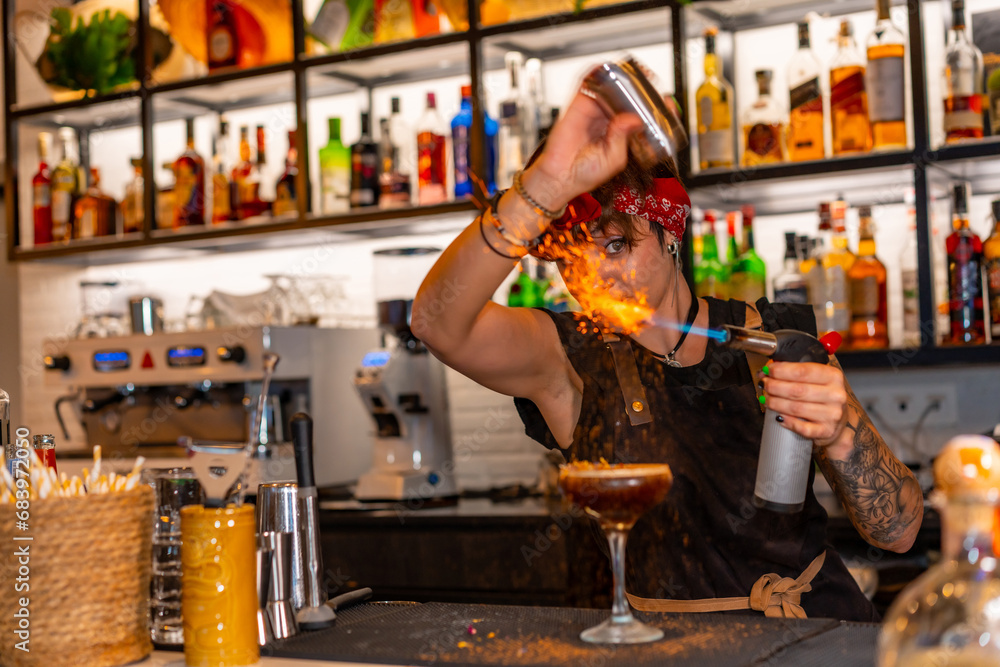 Bartender flaming the decoration of a cocktail