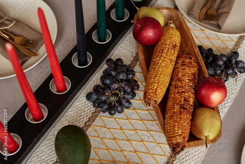 Colorful candles and muhindi ears of corn on table served for Kwanzaa photo