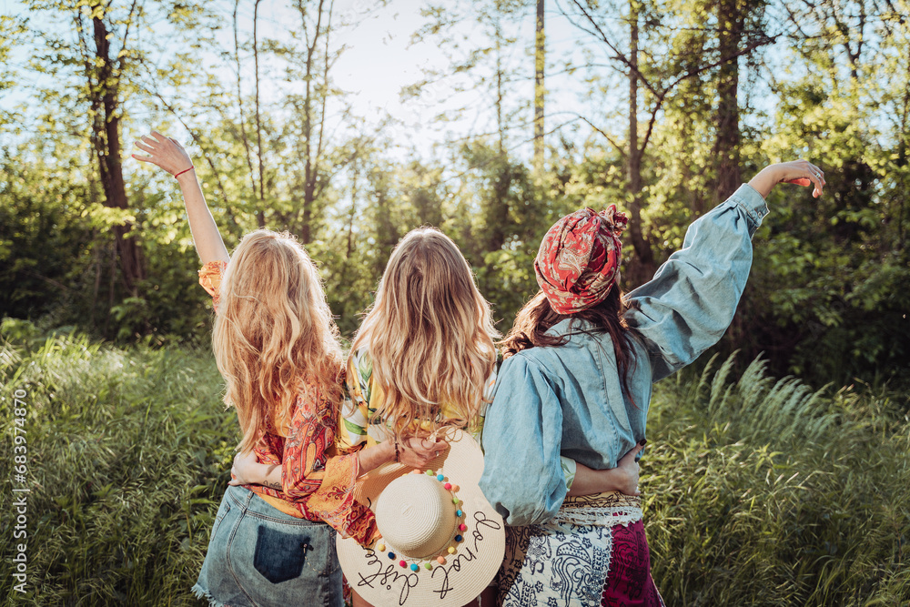 three girls female friends hugging in nature from behind