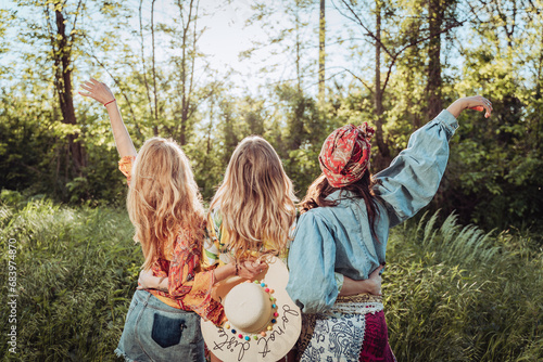 three girls female friends hugging in nature from behind 