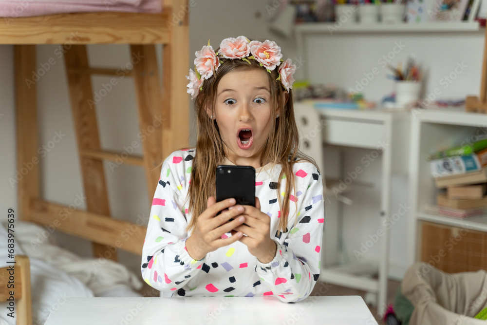 happy little girl in her play room smart phone addicted watching video video game expressions screaming