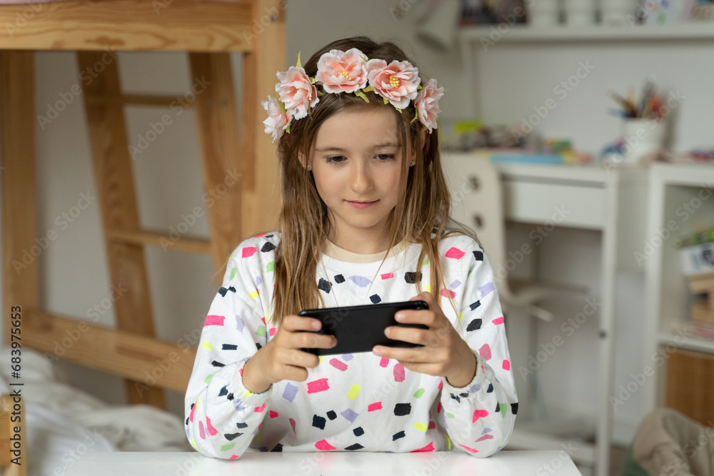 happy little girl in her play room smart phone addicted watching video video game expressions screaming