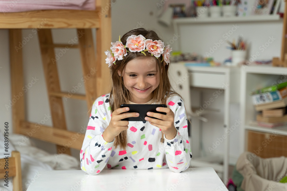 happy little girl in her play room smart phone addicted watching video video game expressions screaming