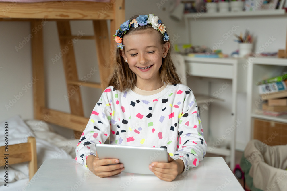happy little girl in her play room watching play learn tablet mobile electronic book happy game